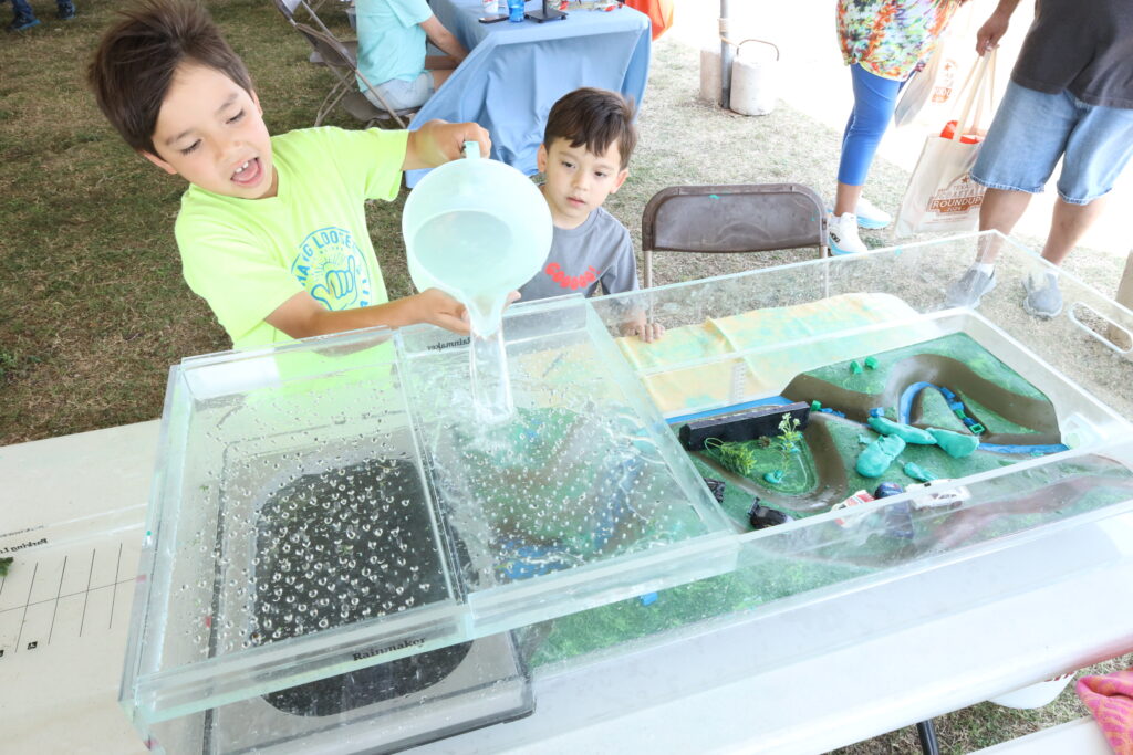 Earth day event with kids pouring water to make flood