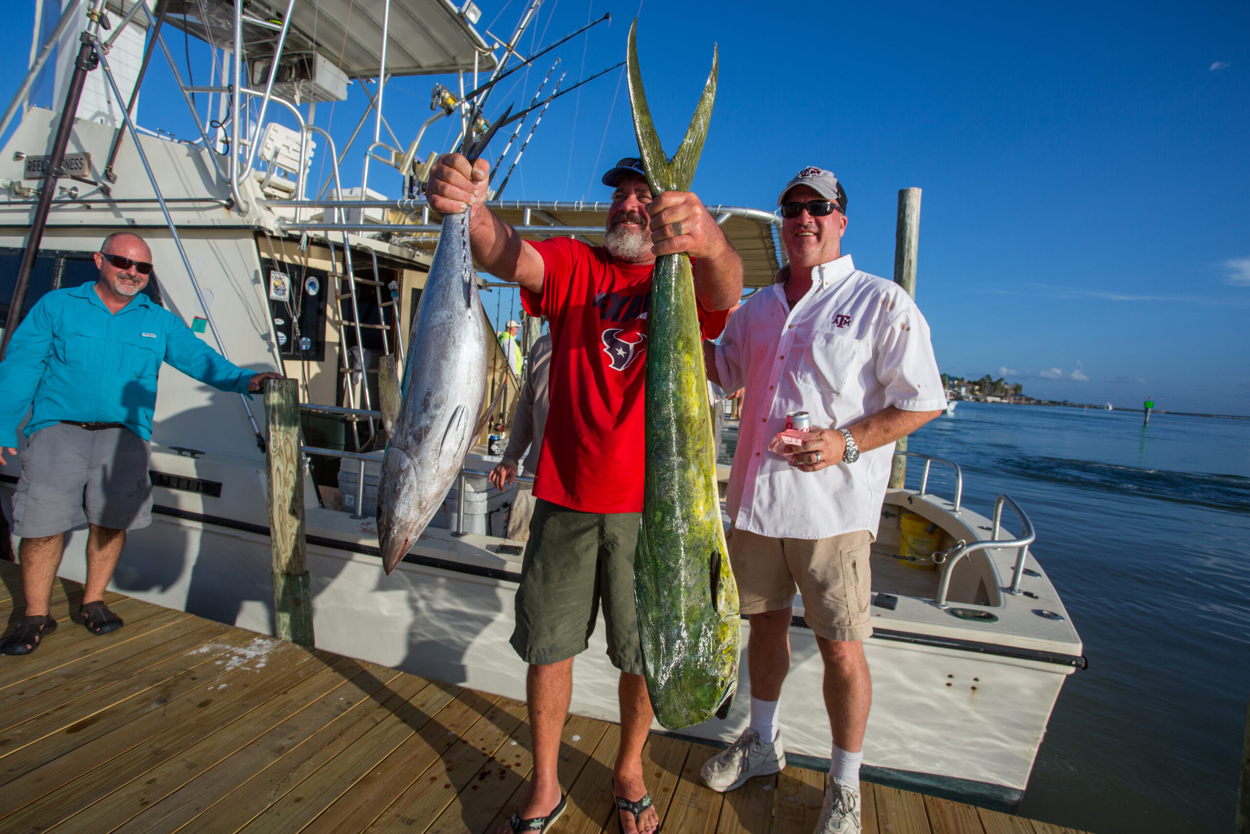 man holding up fish and weighing at tournament