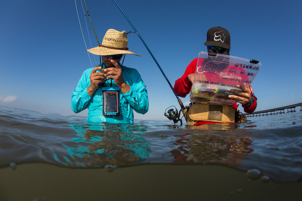 men working on fishing line out on bay