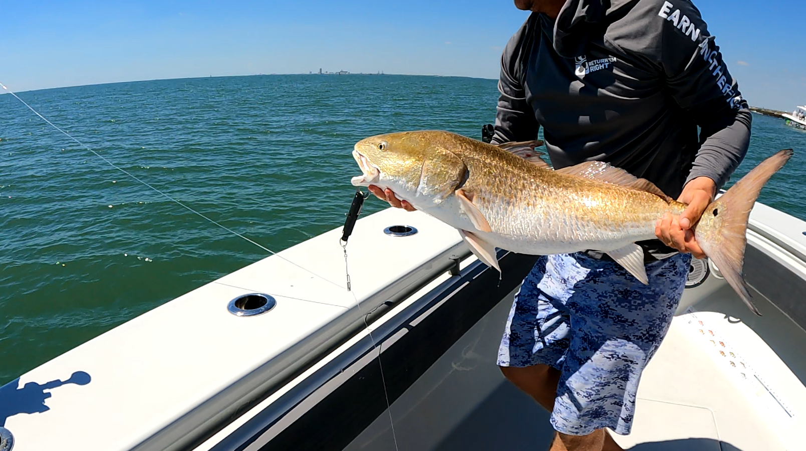 Holding a fish over a boat