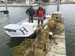 people smiling with crab traps they cleaned from bay