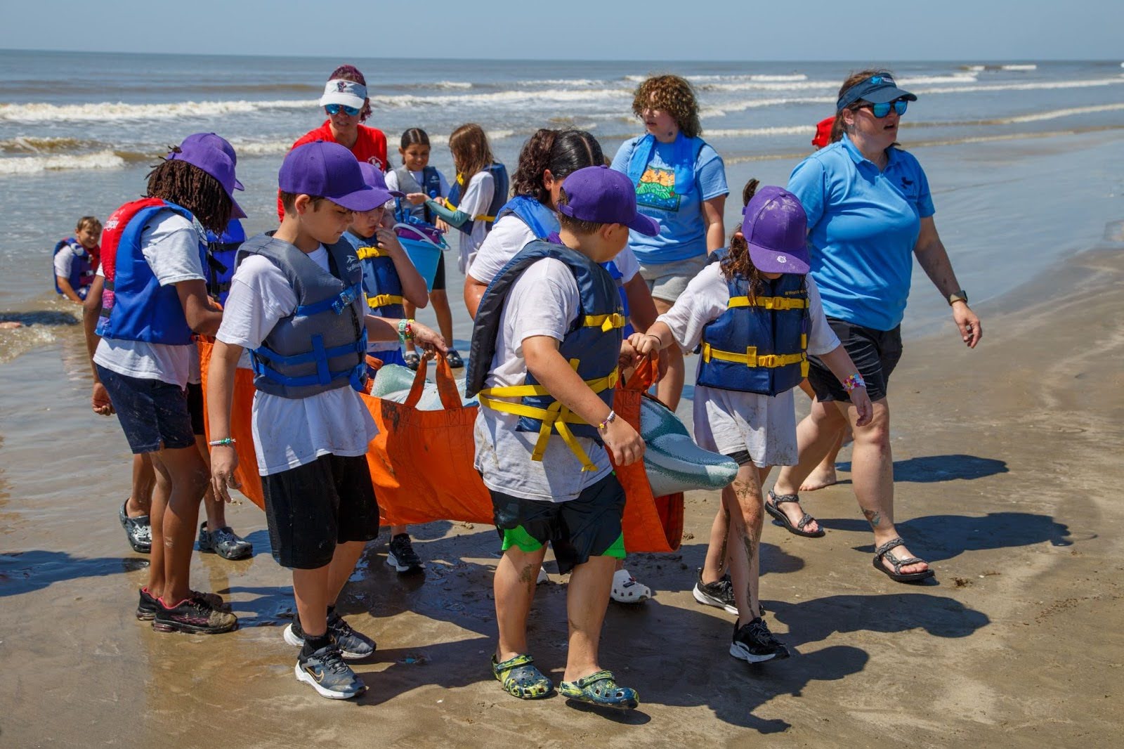 Camp Wild participants on the beach simulating a dolphin rescue